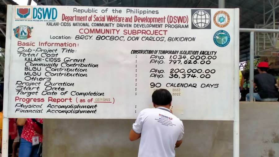 A member of the Area Coordinating Team of Don Carlos, Bukidnon updates details on a KALAHI-CIDSS community subproject marker in Brgy. Bocboc. The community subproject was identified and implemented in the community through the CDD approach.